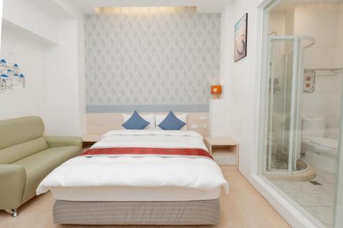 a bedroom with a bed and a couch and a tub at 飛日月漫旅Flying Sun & Moon in Yuchi
