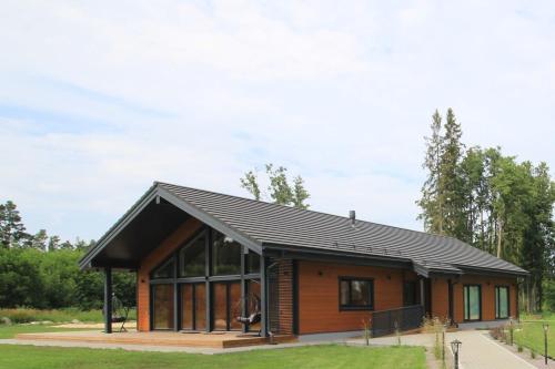 a small house with a black roof at Kuldallika Spa House in Kullamäe