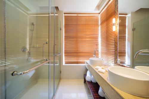 a bathroom with a tub and a sink and a shower at Grand Mercure Sanya Yalong Bay in Sanya