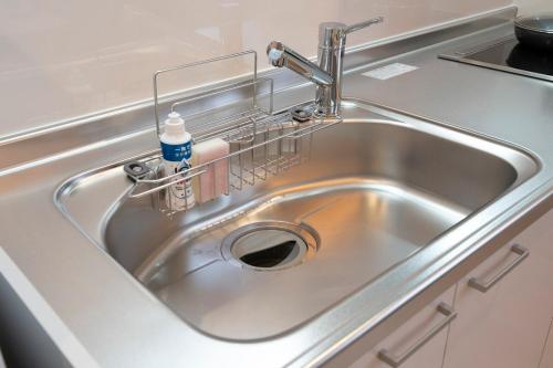 a kitchen sink with a bottle of detergent in it at Precious Hotel 綾川 in Ayagawa