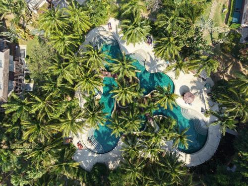 an overhead view of a resort swimming pool with palm trees at Grand Mercure Sanya Yalong Bay in Sanya