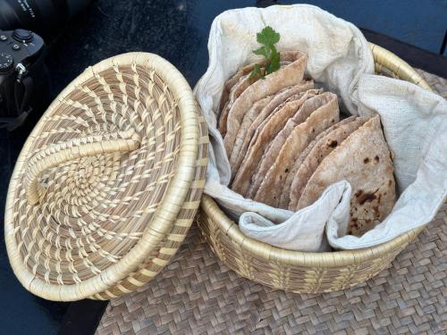 two baskets filled with bread sitting on a table at Sapana Village Lodge in Sauraha