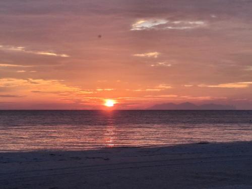 a sunset on the beach with the sun setting at Rompin Beach Resorts in Kuala Rompin