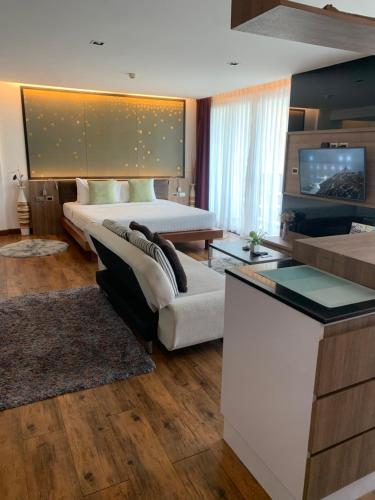 a bedroom with a bed and a couch in a room at Luxury Suite Room by Atlas X in Kata Beach