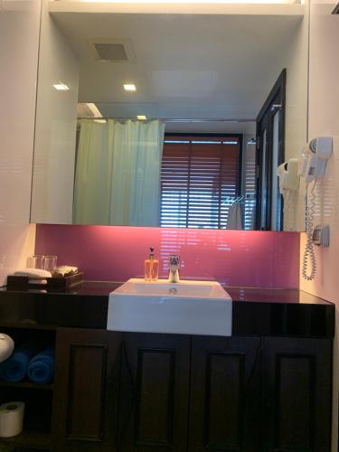 a bathroom with a sink and a large mirror at Luxury Suite Room by Atlas X in Kata Beach