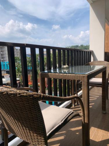 a patio with a table and chairs on a balcony at Luxury Suite Room by Atlas X in Kata Beach