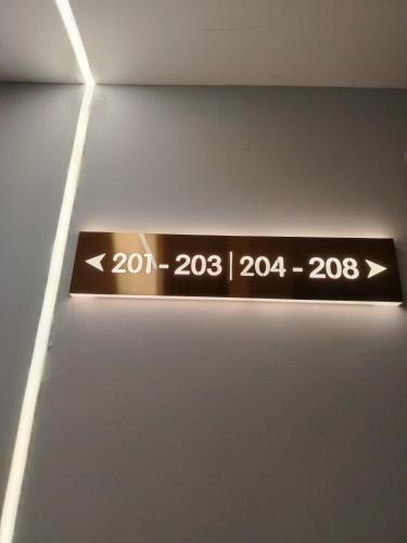 a sign hanging on a wall with two arrows at The great hotel greenhill in Ipoh