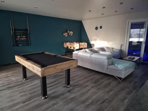 un salon avec une table de billard et un canapé dans l'établissement Maison 5 chambres, à Troarn