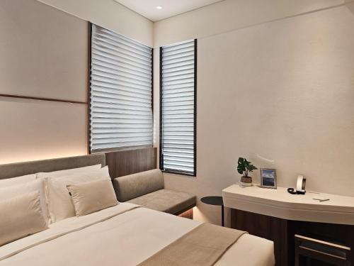 a bedroom with a bed and a desk and a window at The Stellar in Hong Kong