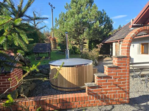 a hot tub in a yard next to a brick building at chalupa Stritez in Střítež