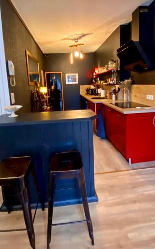 une cuisine avec un comptoir bleu et un bar avec un tabouret dans l'établissement Appartment T3 center Guérande, à Guérande