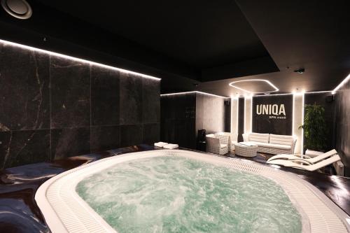 a large jacuzzi tub in a room with chairs at Suncity Hotel & SPA in Šiauliai