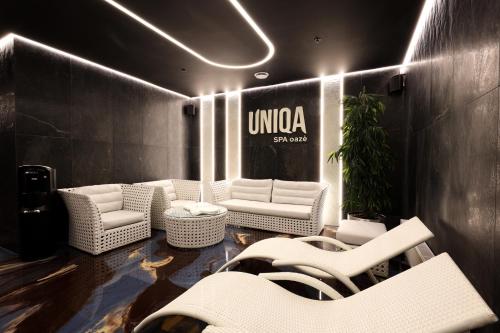 a lobby with white chairs and a sign on a wall at Suncity Hotel & SPA in Šiauliai