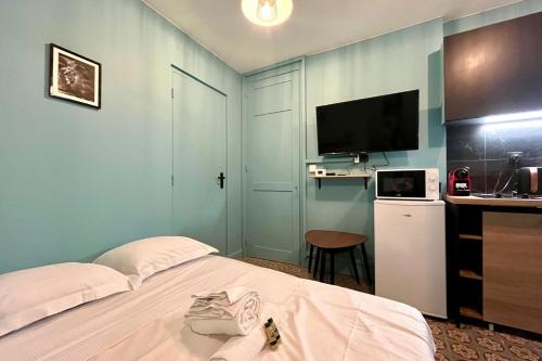- une chambre avec un lit, une télévision et un bureau dans l'établissement Le nid des Dominicains, à Nancy