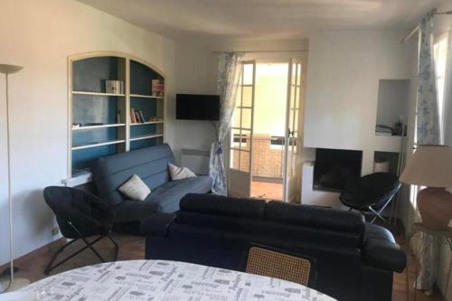 un salon avec un canapé bleu et une table dans l'établissement Charming T3 terrace near the sea, à Saint-Cyr-sur-Mer