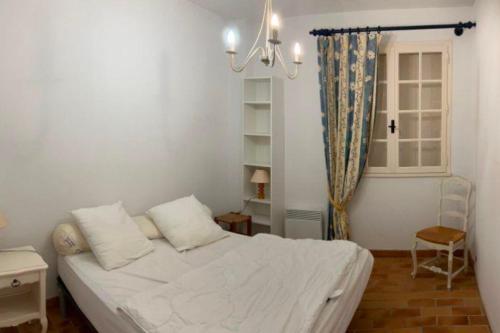 une chambre avec un lit blanc et une fenêtre dans l'établissement Charming T3 terrace near the sea, à Saint-Cyr-sur-Mer