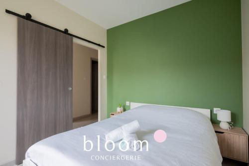 - une chambre avec un lit blanc et un panneau coopératif fleuri dans l'établissement Le cocon de Solignac appartement neuf, à Nancy