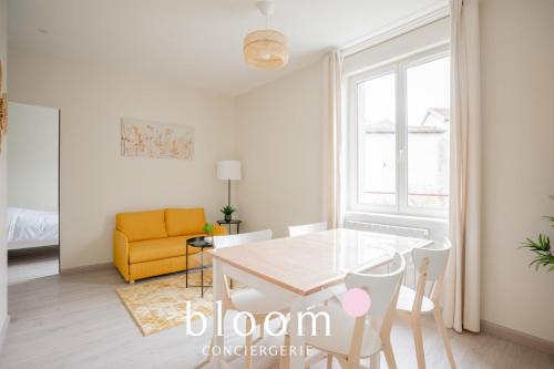 une salle à manger avec une table et une chaise jaune dans l'établissement Le cocon de Solignac appartement neuf, à Nancy
