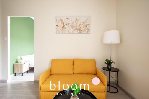 - un canapé jaune dans le salon avec une lampe dans l'établissement Le cocon de Solignac appartement neuf, à Nancy
