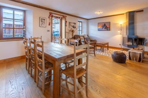 - une salle à manger et un salon avec une table et des chaises en bois dans l'établissement Chalet Mil, à Les Allues