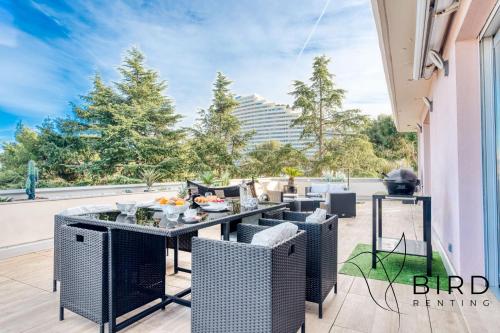 un patio avec une table, des chaises et un barbecue dans l'établissement Ideal two-room apartment with a large terrace and parking, à Villeneuve-Loubet