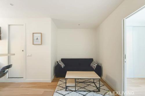 un salon avec un canapé et une table dans l'établissement Flexliving - T2 - Montreuil, à Paris