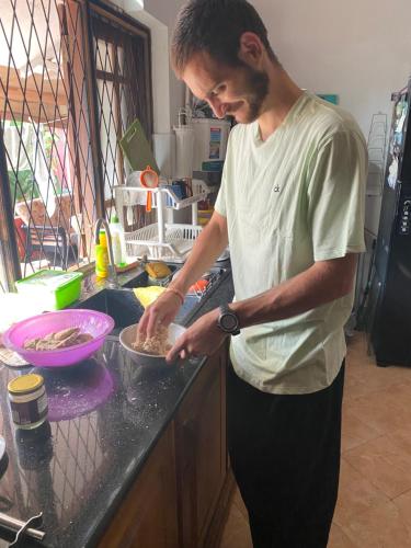 a man standing in a kitchen preparing food in a bowl at Grace Green Ville in Negombo