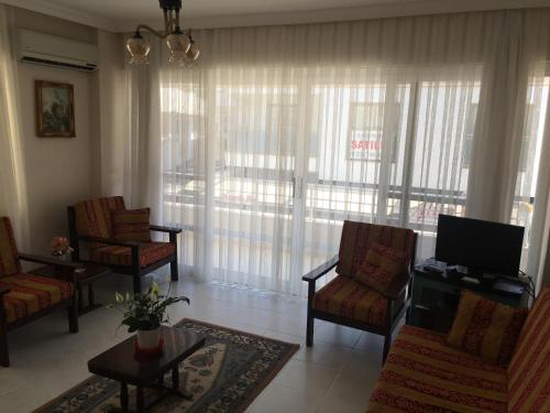 a living room with chairs and a flat screen tv at Cavide Hanım Apart in Didim