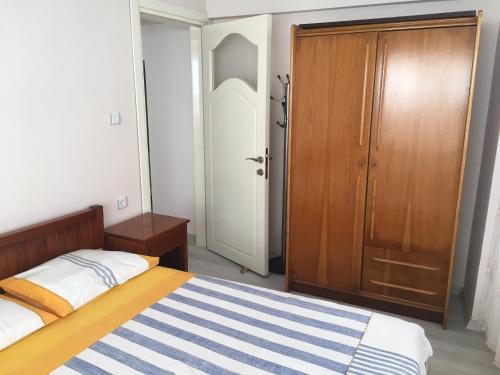 a bedroom with a bed and a wooden door at Cavide Hanım Apart in Didim