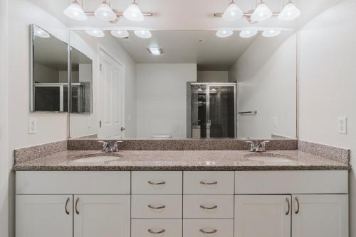 a bathroom with two sinks and a large mirror at Blueground San Mateo pool wd nr park SFO-1807 in San Francisco