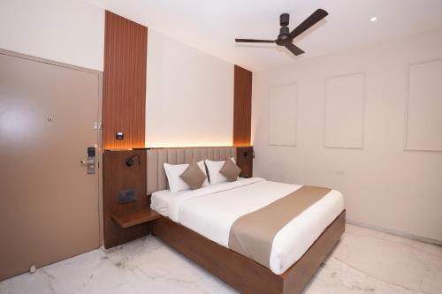 a bedroom with a large bed with a ceiling fan at Vaishnavi Residency in Bengaluru