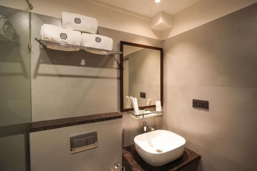 a bathroom with a toilet and a sink and a mirror at Vaishnavi Residency in Bengaluru