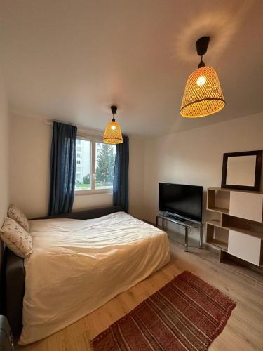 - une chambre avec un lit, deux lumières et une télévision dans l'établissement Apartment - 2 rooms - Malakoff, à Malakoff