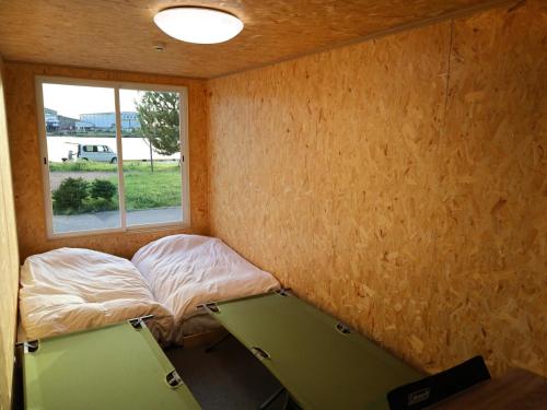 酒田市にあるＳＡＫＡＴＡＮＴＯ Ｃｏｎｔａｉｎｅｒ Ｈｏｔｅｌ ＣＡＭＰＳ - Vacation STAY 93788vのベッドと窓のある小さな部屋