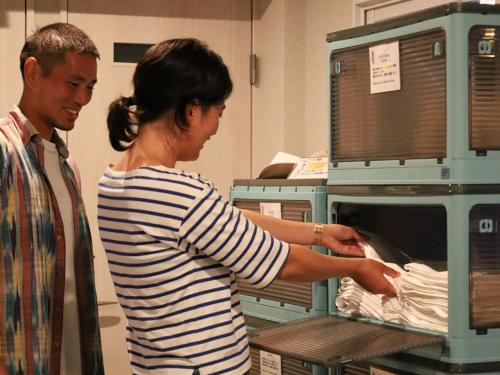 a man and a woman putting something in an oven at ＳＡＫＡＴＡＮＴＯ Ｃｏｎｔａｉｎｅｒ Ｈｏｔｅｌ ＣＡＭＰＳ - Vacation STAY 93807v in Sakata