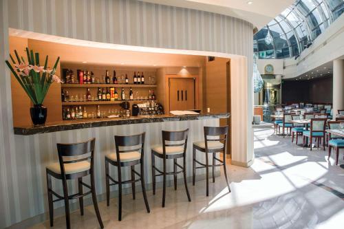 a bar in a restaurant with stools at Howard Johnson Plaza by Wyndham Buenos Aires Florida Street in Buenos Aires