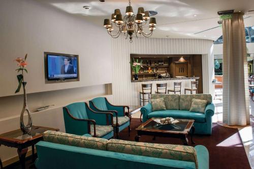 a living room with a couch and chairs and a table at Howard Johnson Plaza by Wyndham Buenos Aires Florida Street in Buenos Aires