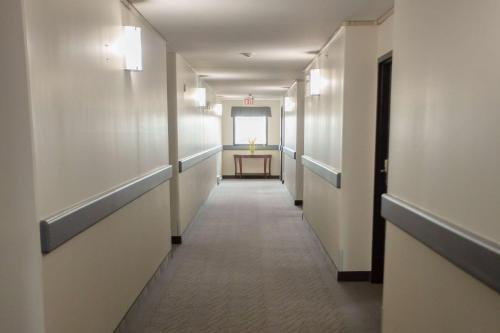a corridor of a hospital hallway with a table in the distance at Super 8 by Wyndham Whitecourt in Whitecourt