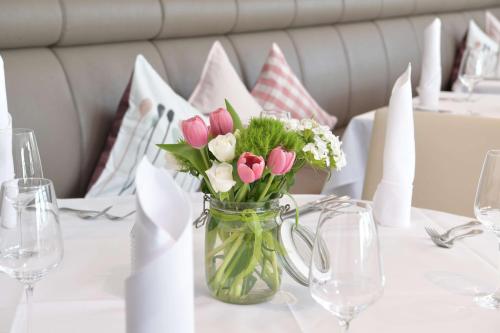 a vase filled with pink and white flowers on a table at Best Western Queens Hotel Pforzheim-Niefern in Pforzheim