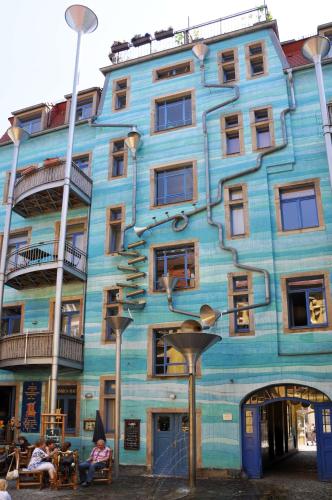 a blue building with people sitting outside of it at Best Western Macrander Hotel Dresden in Dresden