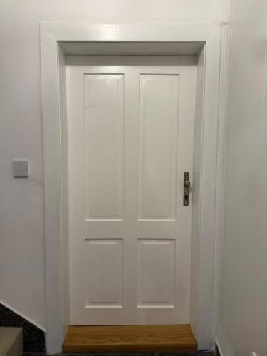 a white door in a room with a wooden floor at Školní 60 in Pelhřimov