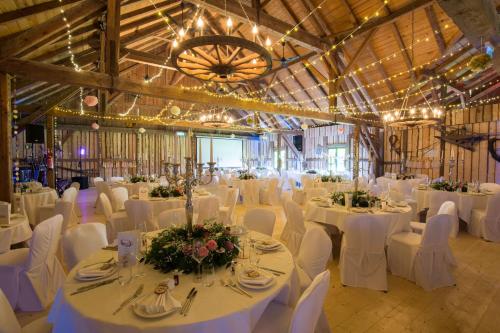 a banquet hall with white tables and white chairs at Hotel Bayerischer Hof Miesbach, BW Premier Collection in Miesbach