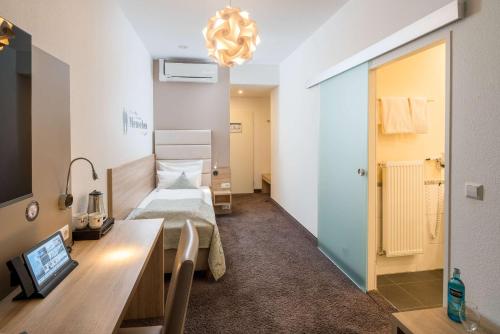 a room with a bed and a desk in a room at Best Western Hotel Lamm in Singen