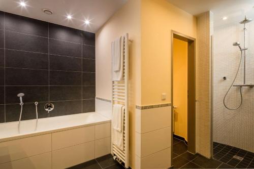 a bathroom with a bath tub and a shower at Best Western Hotel Lamm in Singen