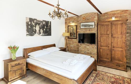 a bedroom with a bed and a brick wall at Ułańska Zagroda in Człopa