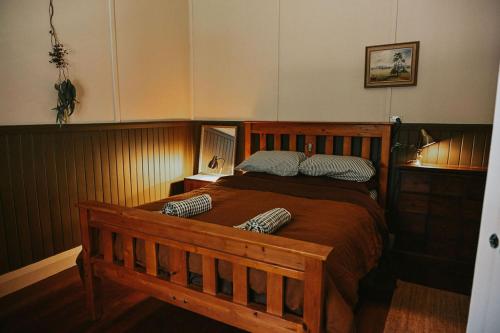 a bedroom with a wooden bed with two pillows on it at Two Brothers' Cabin in Deeside