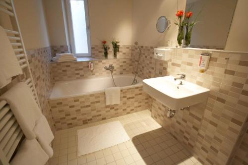 a bathroom with a tub and a sink and a bath tub at Best Western Hotel am Spittelmarkt in Berlin