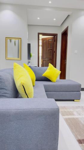 a blue couch with yellow pillows in a living room at SN suites apartment in Bulambiro