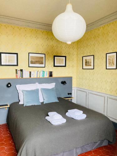 une chambre avec un grand lit avec des serviettes dessus dans l'établissement Le Presbytère de Darcey, à Darcey