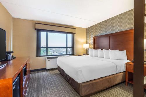 a hotel room with a large bed and a television at Comfort Inn & Suites Logan International Airport in Revere